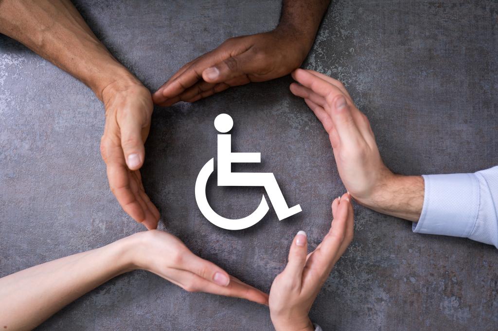 Close-up Of A Hands Protecting Disabled Handicap Icon in correlation with ACCESSIBILITY IN TÓRSHAVN, Faroe Islands
